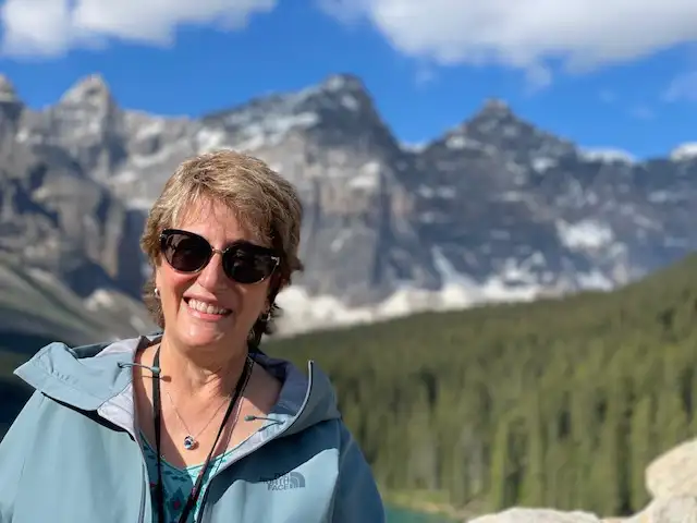 Photo of Susan Ahlquist with a mountain range behind her